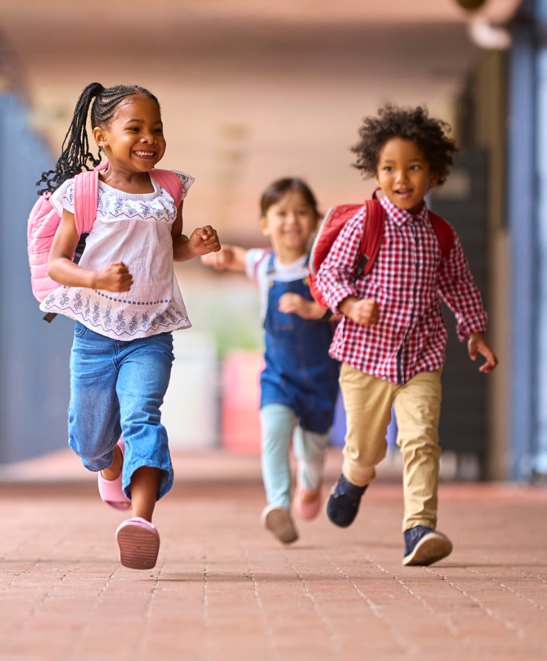 A group of kids wearing backpacks running