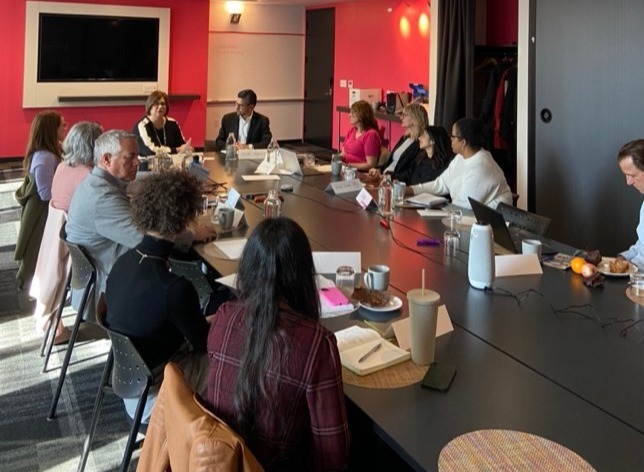 Members of HEAL sitting in discussion around a boardroom table.