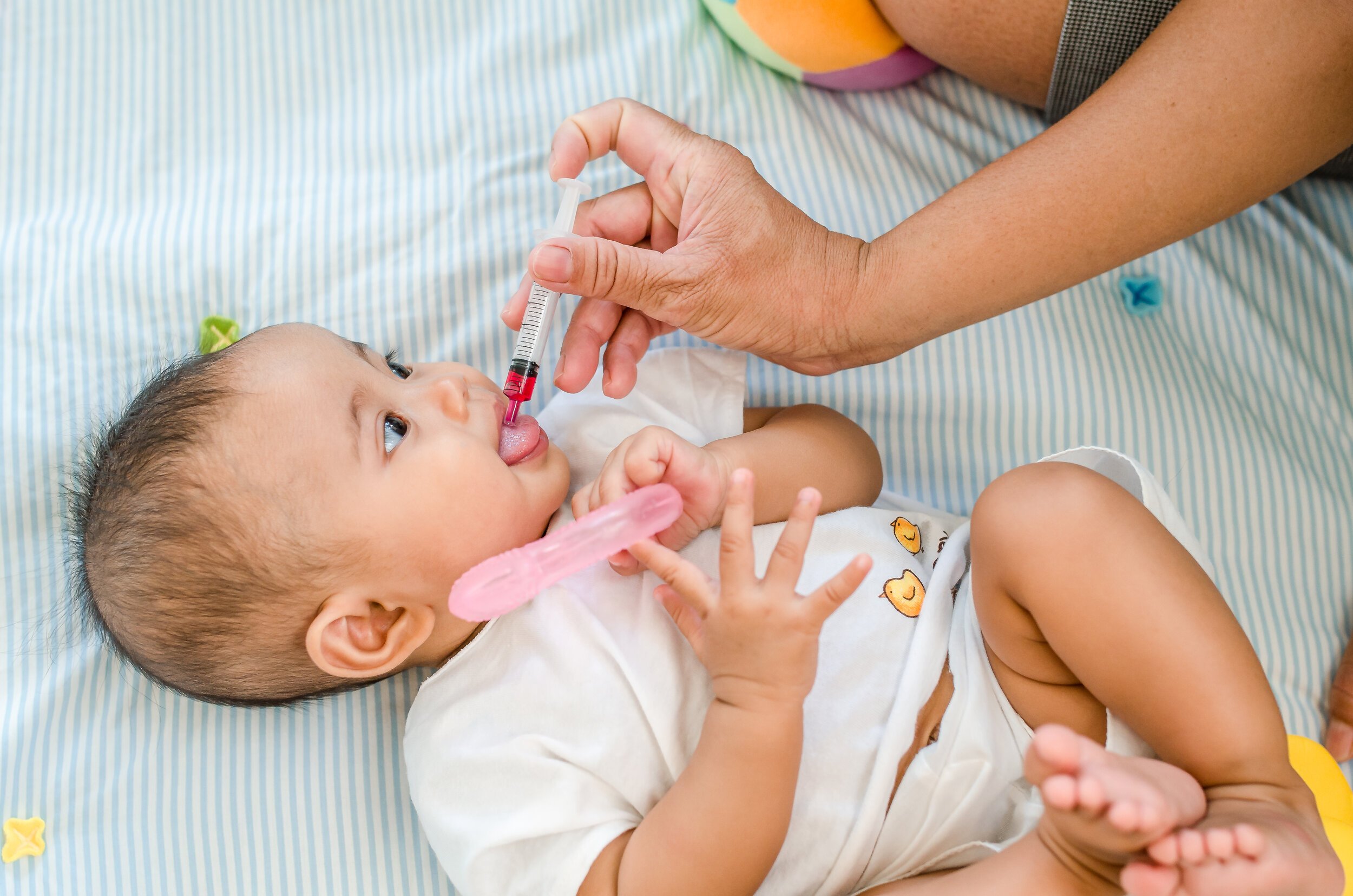 baby receiving medication through an oral syringe