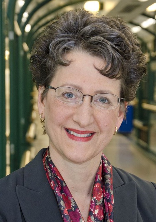 Image of smiling Caucasian woman with brown hair and glasses