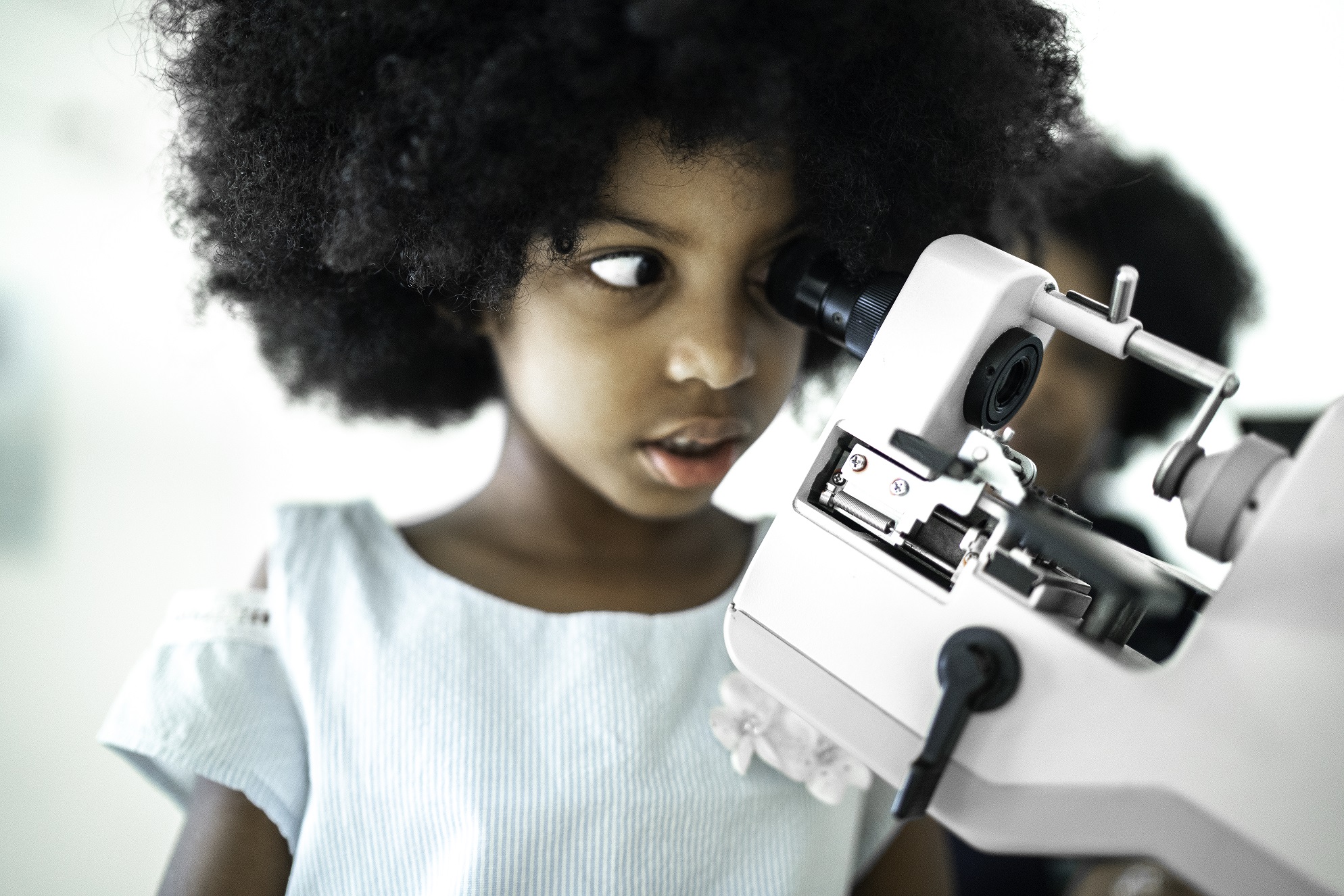 child looking through microscope
