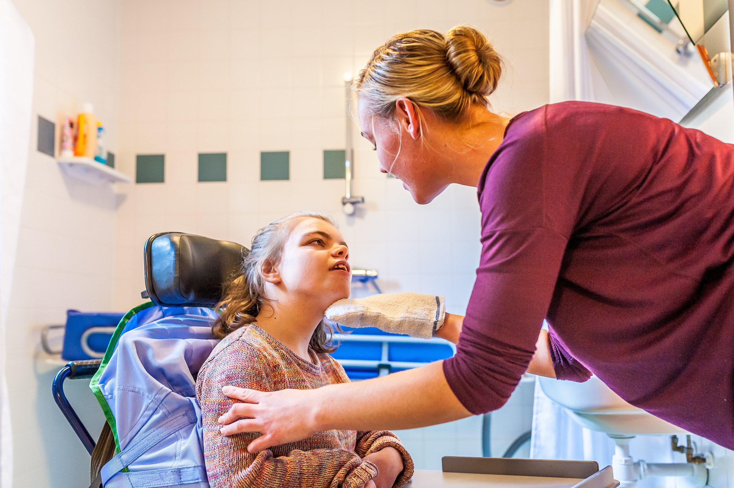 young  girl in wheelchair with personal support worker