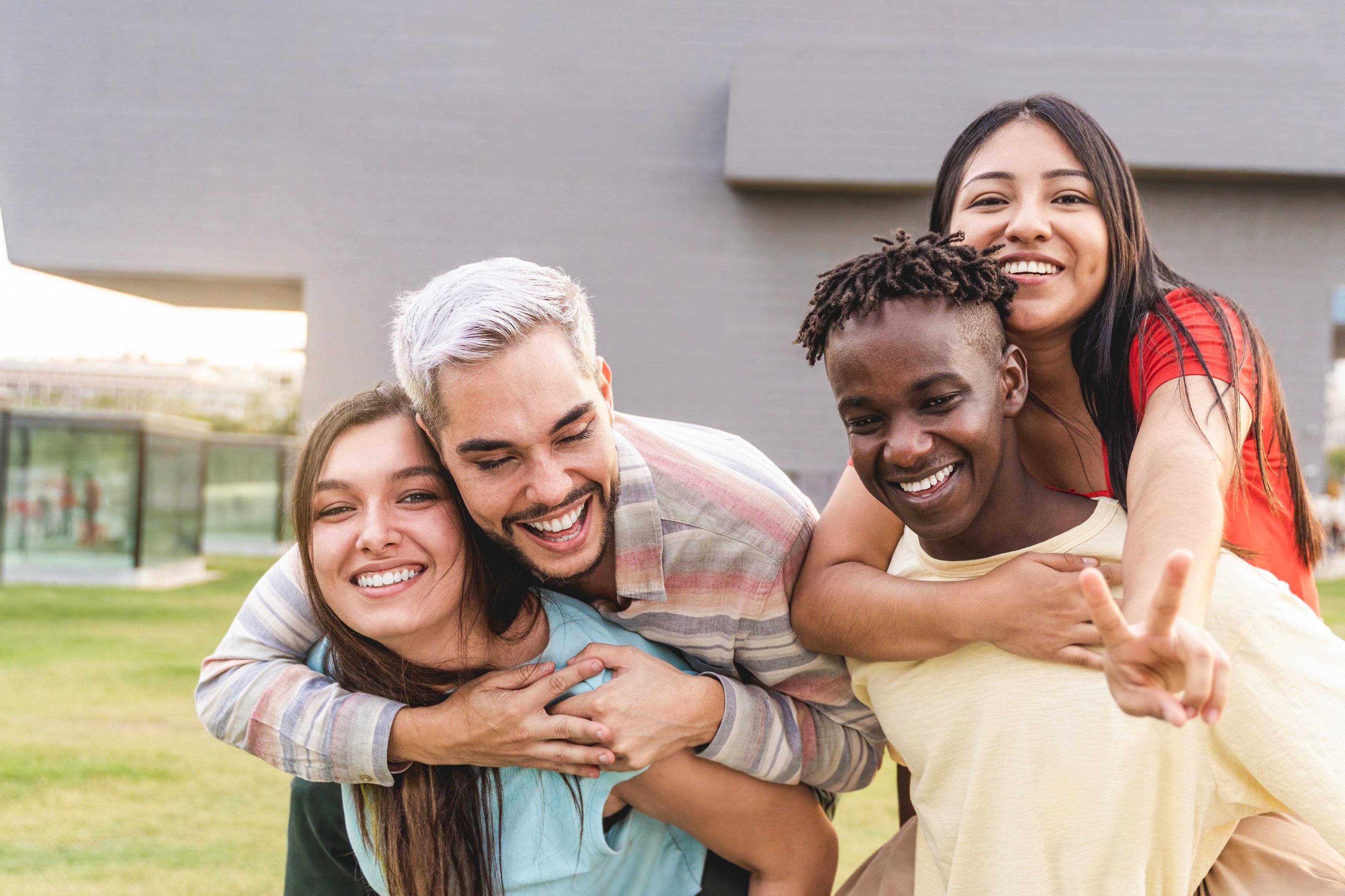 Four youth outside giving piggy backs