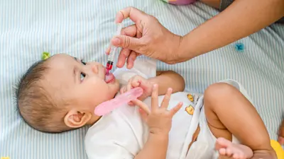 baby receiving medication through an oral syringe