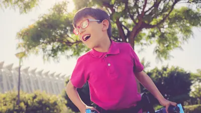 Young boy in pink shirt using walker